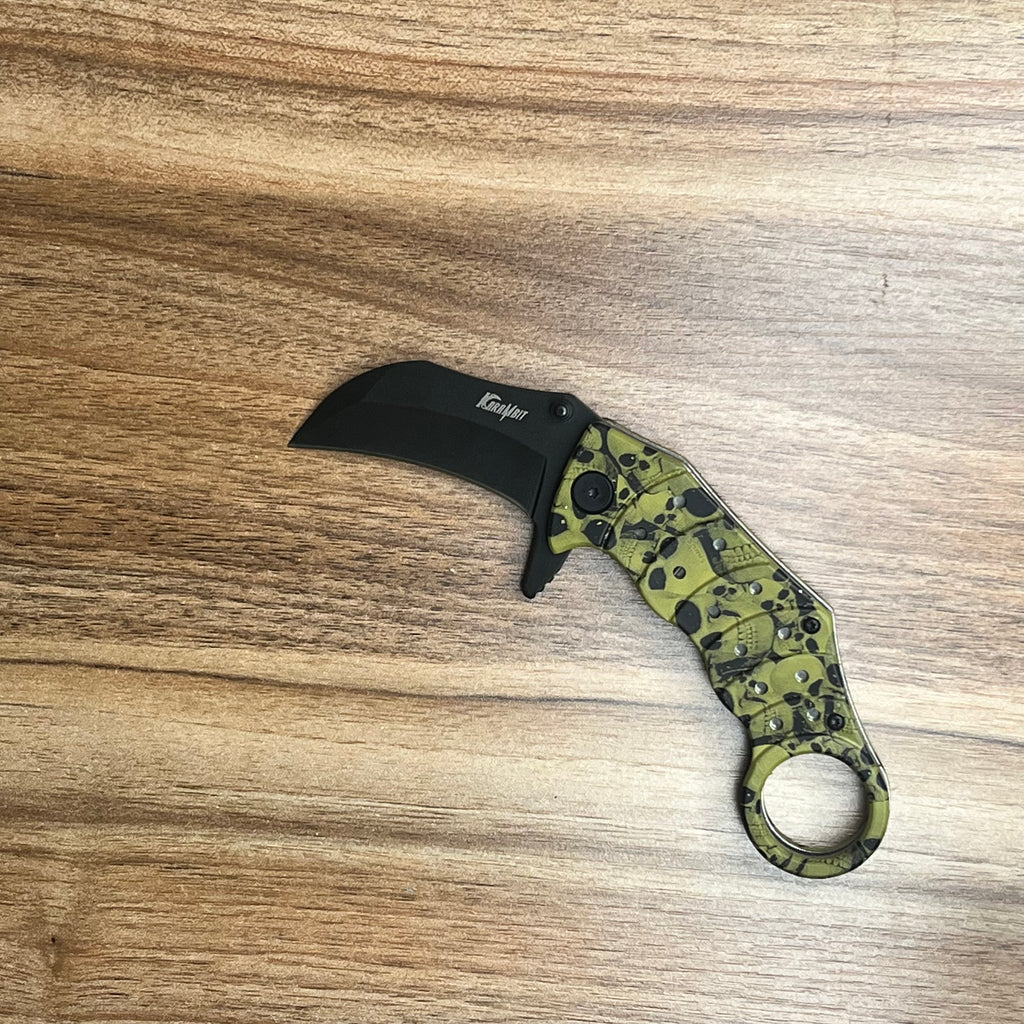 Green karambit knife with a skull pattern on the handle and a black blade