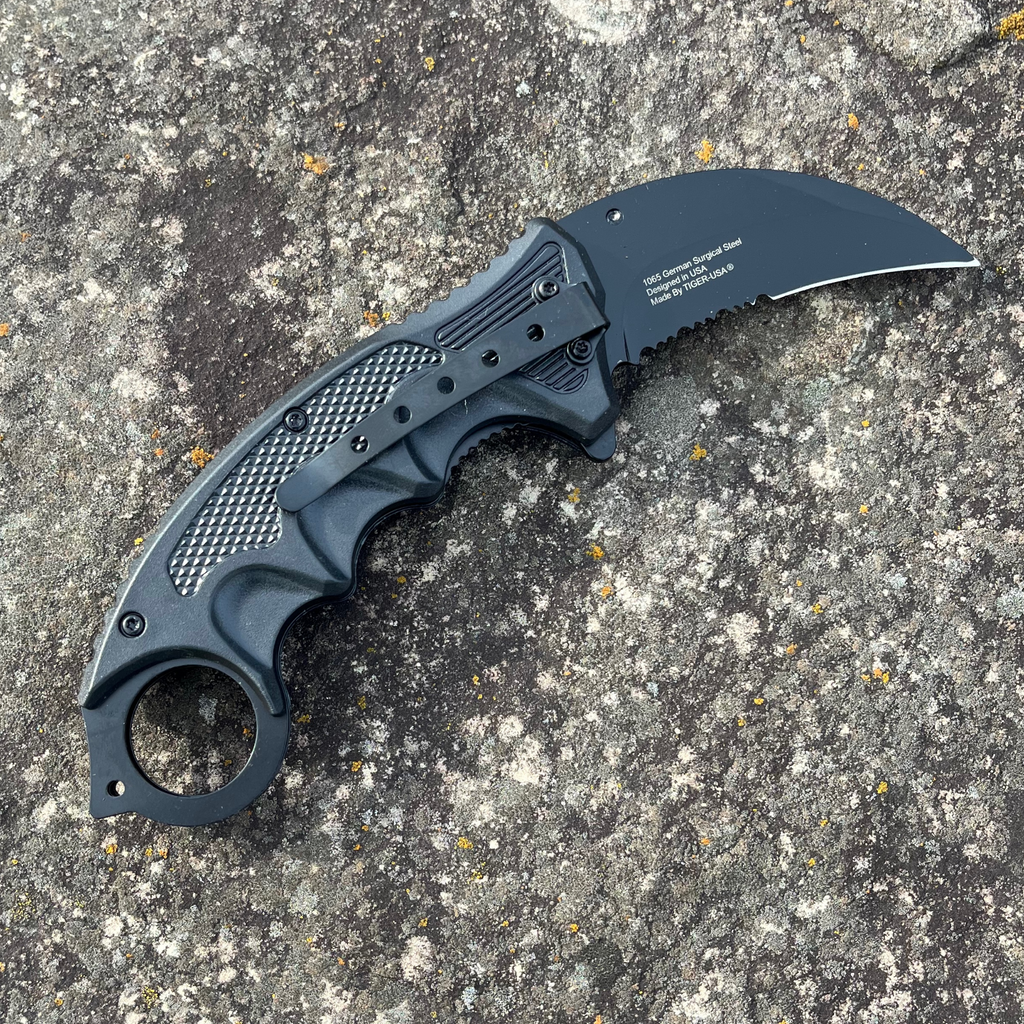 Measuring 7.5 inches in length, this Grunge Flag Karambit folding knife features a 1065 German surgical steel blade, making it an official Tiger-USA® knife. A weighing 4.27 ounces, this knife is heavy duty and spring assisted, yet remains affordable.